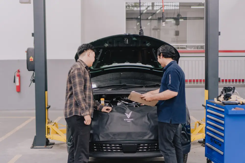 teknisi sedang menjelaskan kondisi mobil listrik kepada customer