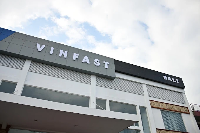 Gedung dealer VinFast Bali modern dengan tulisan 'VINFAST' dan 'BALI' di bawah langit cerah, sebagai wujud nyata dari filosofi brand untuk hadir melayani pelanggan.