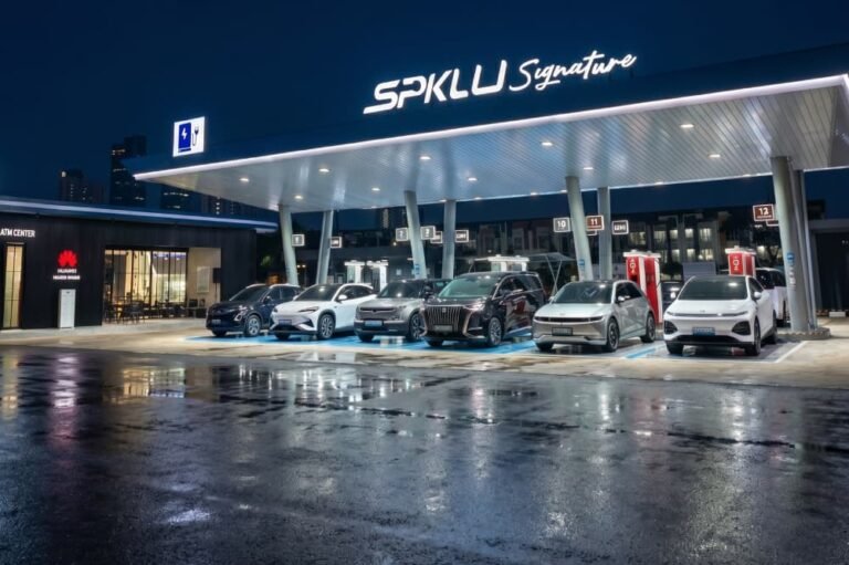 Stasiun Pengisian Kendaraan Listrik Umum (SPKLU) PLN Signature dengan deretan mobil listrik di malam hari.